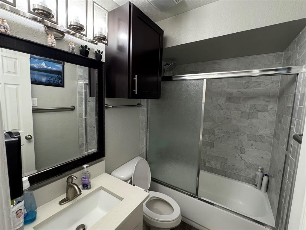 320 Pecan Street Wilmer, TX 75172 - Photo 13 of 25 Bathroom with shower / bath combination with glass door and vanity