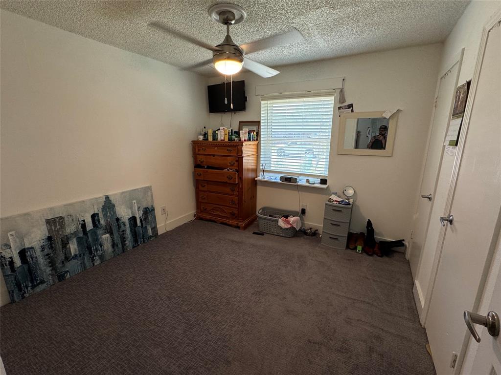 320 Pecan Street Wilmer, TX 75172 - Photo 14 of 25 Bedroom with dark colored carpet, a ceiling fan, and a textured ceiling