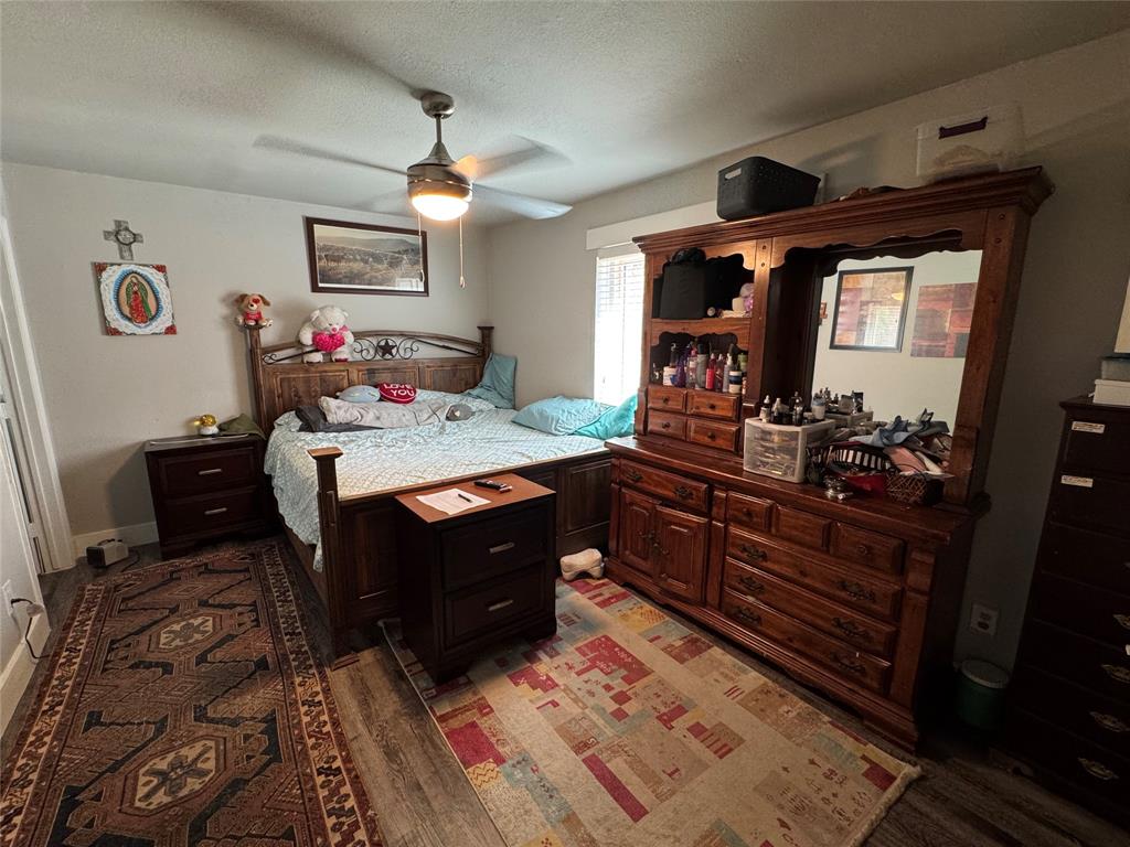 320 Pecan Street Wilmer, TX 75172 - Photo 15 of 25 Bedroom with wood finished floors, ceiling fan, and a textured ceiling