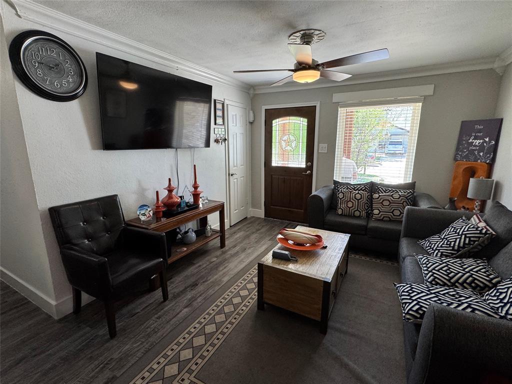320 Pecan Street Wilmer, TX 75172 - Photo 4 of 25 Living area featuring crown molding, dark wood finished floors, ceiling fan, and a textured ceiling