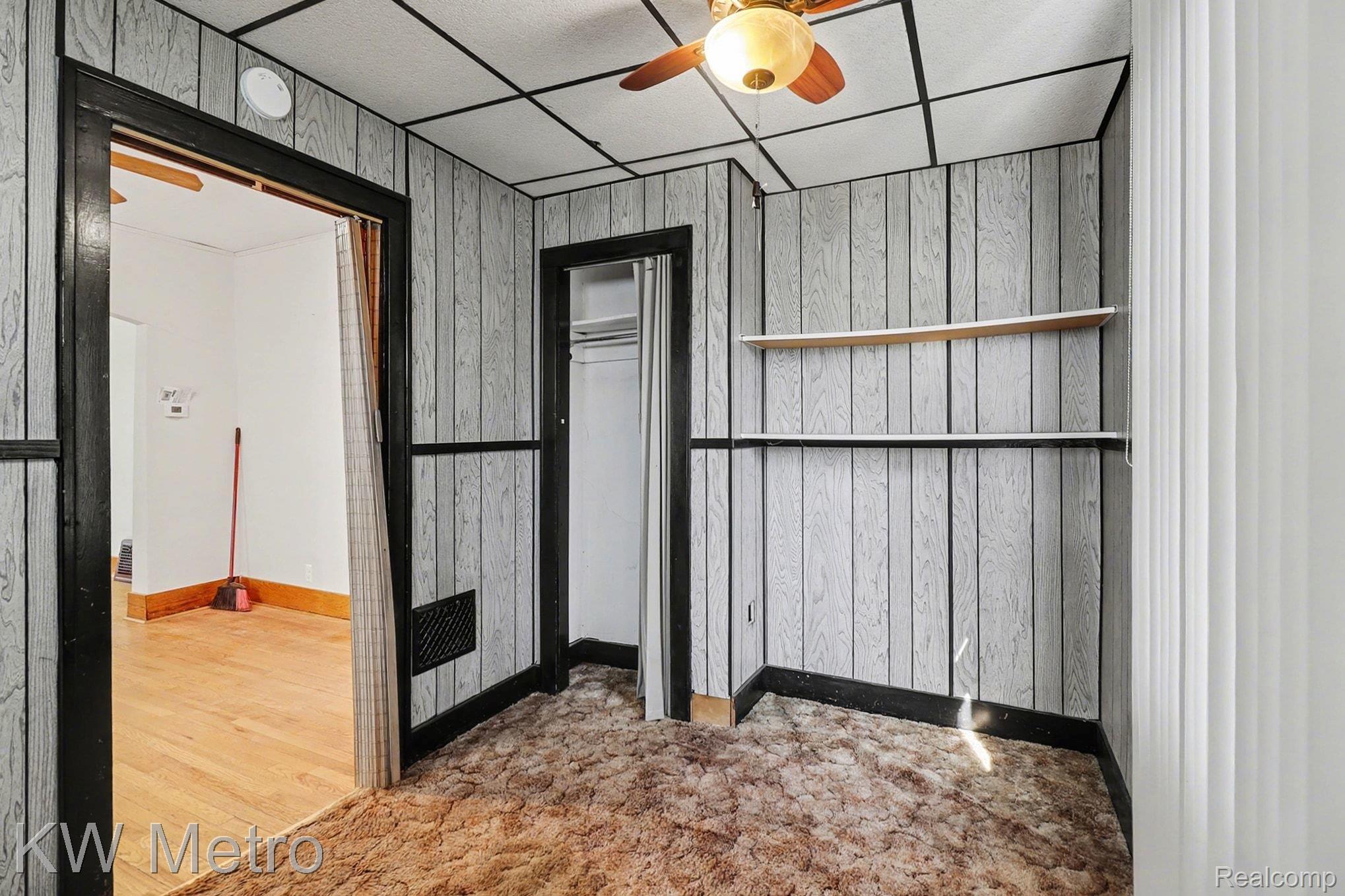 85 Walnut Street River Rouge, MI 48218 - Photo 17 of 20 Unfurnished bedroom featuring wooden walls, a paneled ceiling, and a ceiling fan