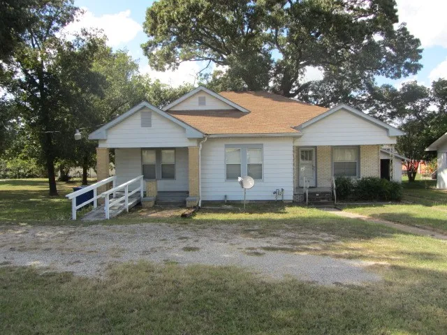 a view of a house with a yard and sitting area