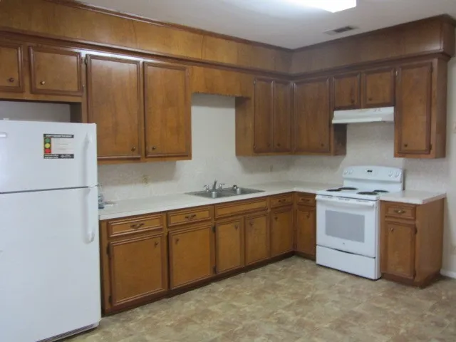 a kitchen with stainless steel appliances granite countertop a refrigerator and a stove top oven