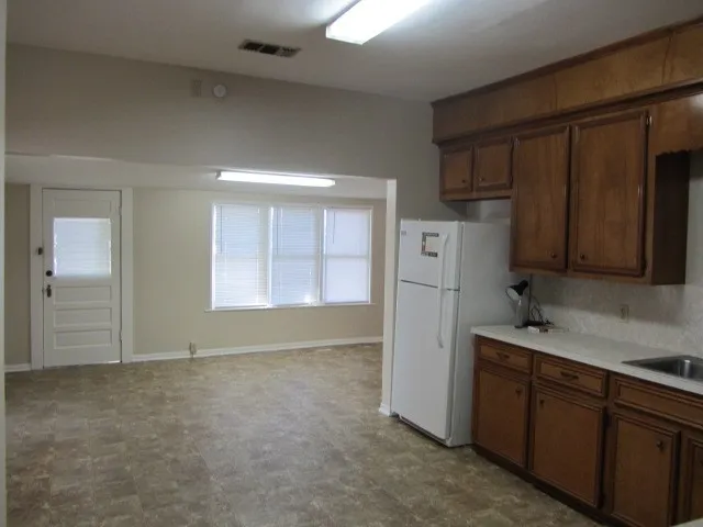 a kitchen with cabinets and a refrigerator
