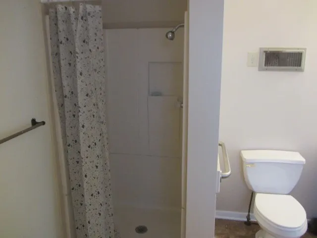 a bathroom with a toilet and a shower