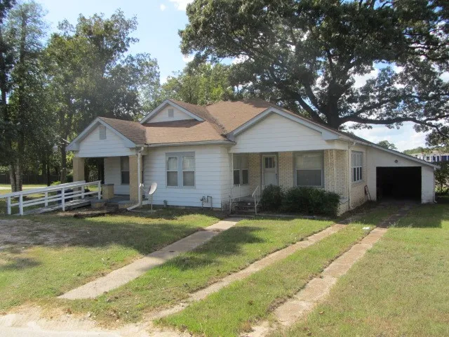 a front view of a house with a garden and patio