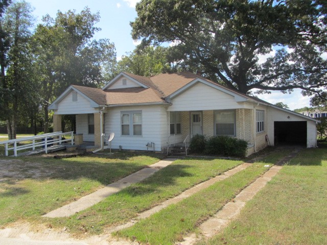 3002 Montgomery Road Huntsville, TX 77340 - Photo 2 of 27 a front view of a house with a garden and patio