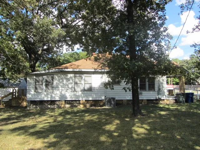 a view of a house with a yard balcony and tree