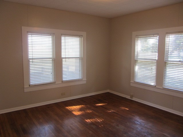 3002 Montgomery Road Huntsville, TX 77340 - Photo 5 of 27 a view of an empty room with wooden floor and a window