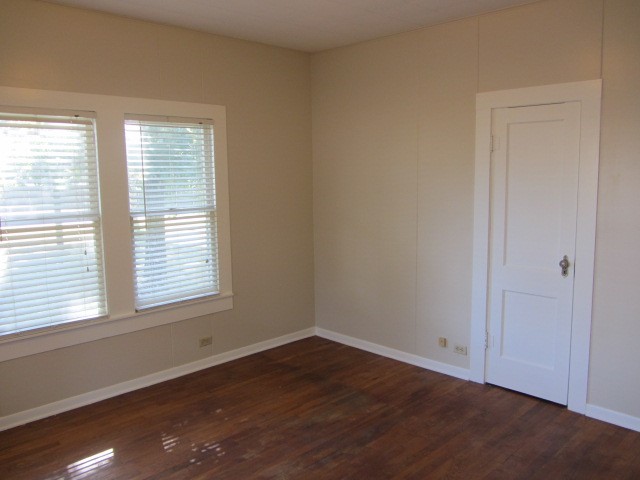 3002 Montgomery Road Huntsville, TX 77340 - Photo 6 of 27 an empty room with wooden floor and windows