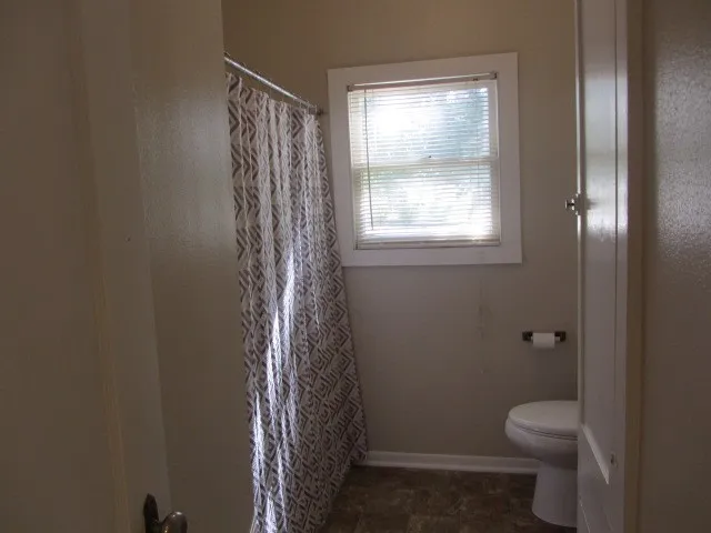 a bathroom with a toilet and a shower