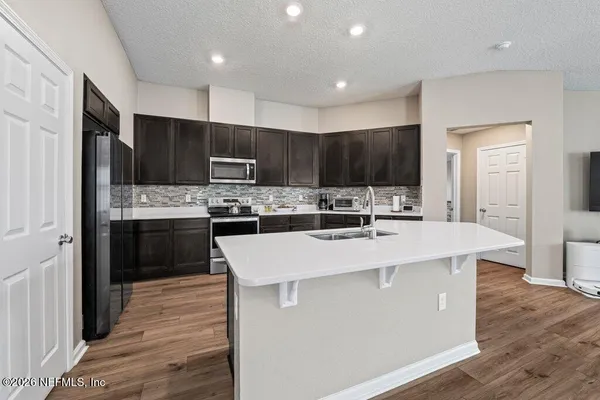 a kitchen with kitchen island stainless steel appliances a refrigerator cabinets a sink and a oven