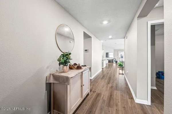 a view of a hallway with wooden floor windows and a bathroom