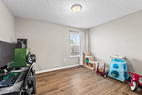 a view of a room with wooden floor and a window