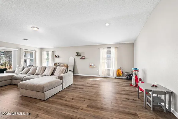 a living room with furniture and wooden floor