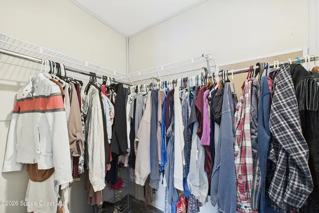 a view of walk in closet with clothes