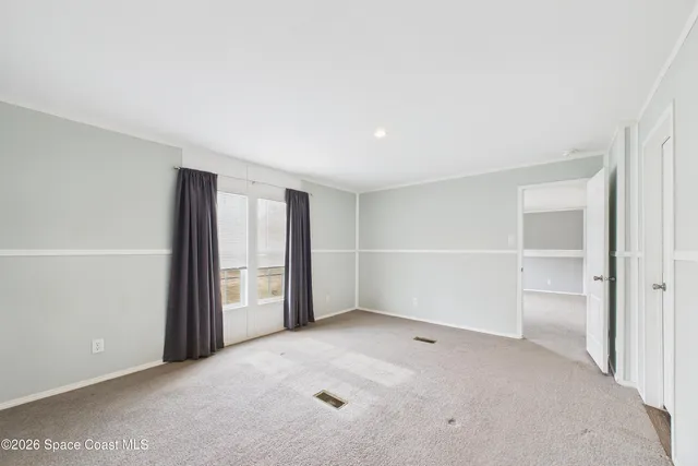 an empty room with closet and windows