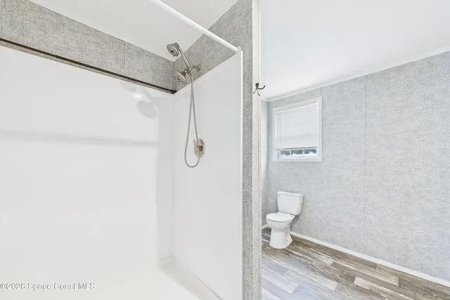 a bathroom with a white toilet and a shower