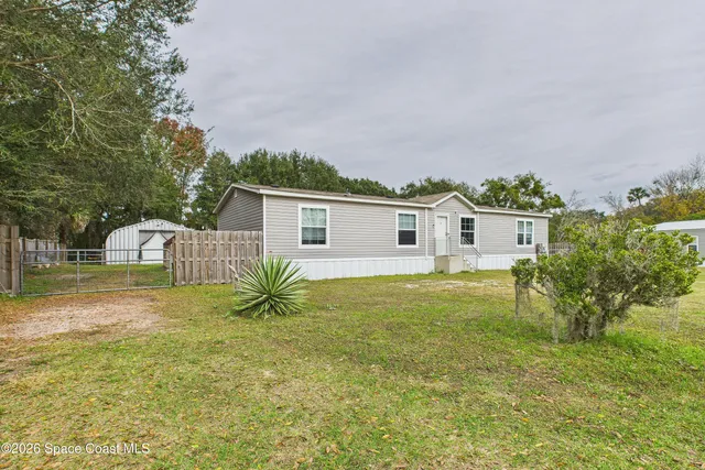 a view of a house with a yard and a large tree center