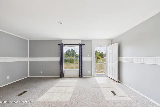 a view of an empty room with a fireplace and a window