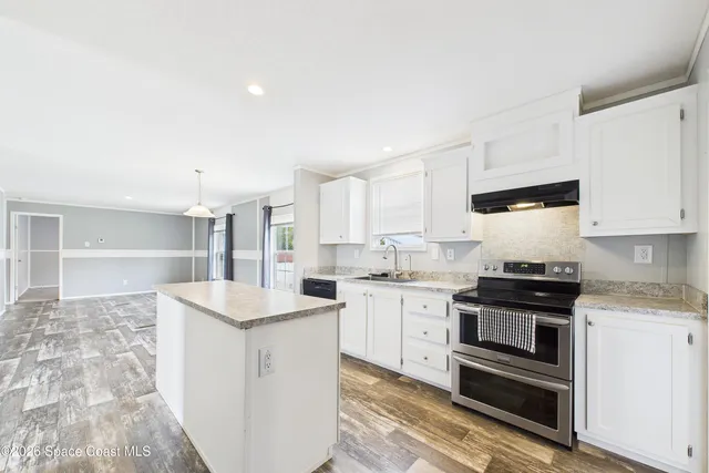 a kitchen with stainless steel appliances granite countertop a sink stove and cabinets