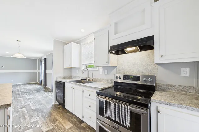 a kitchen with stainless steel appliances a sink stove and cabinets