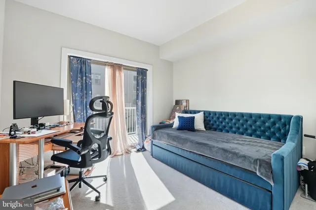 a living room with furniture a flat screen tv and a window