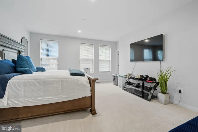 a spacious bedroom with a bed and a flat screen television