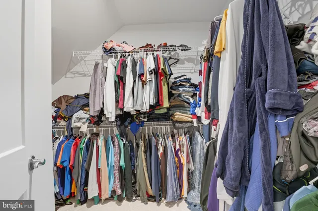 a view of a walk in closet with clothes