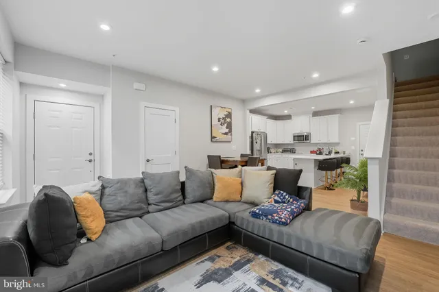 a living room with furniture and a view of kitchen