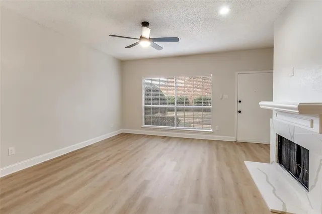 a view of wooden floor fire place and windows in a room