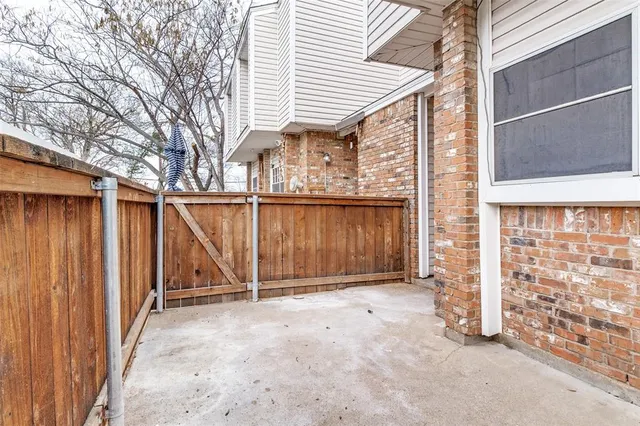 a view of a house with backyard and wooden fence