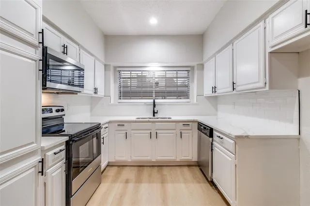a kitchen with stainless steel appliances granite countertop a sink stove and cabinets