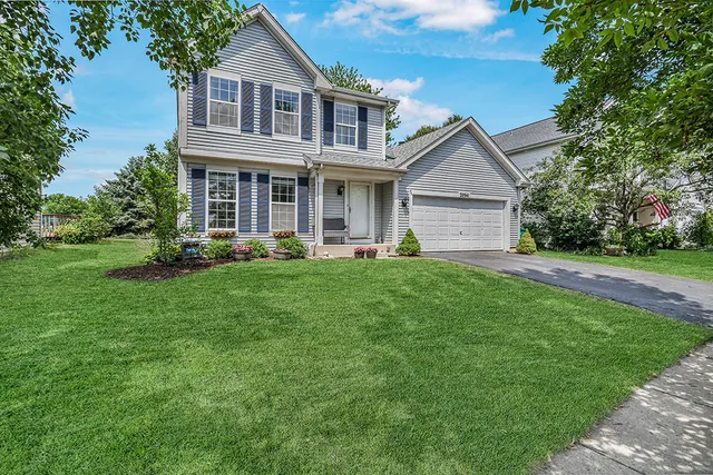 a front view of a house with a yard and trees