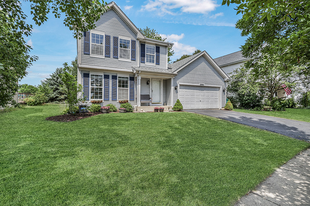 a front view of a house with a yard and trees