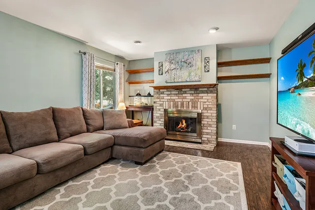 a living room with furniture a flat screen tv and a fireplace