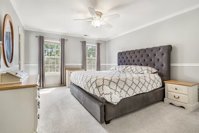 a bedroom with a large bed and a chandelier