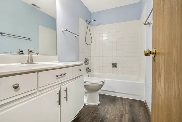 a bathroom with a double vanity sink toilet mirror and shower