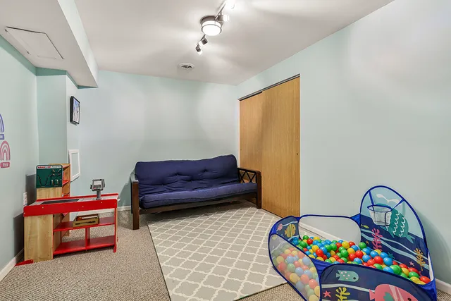 a living room with furniture and a baby crib