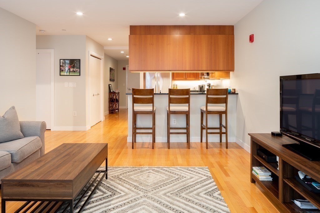 80 Broad Street, Unit 403 Boston, MA 02110 - Photo 1 of 16 a living room with furniture and a flat screen tv
