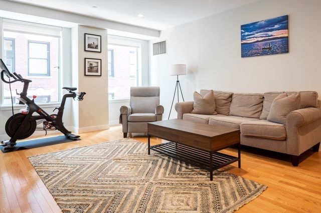 a living room with furniture a rug and a window