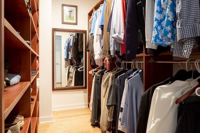 a view of walk in closet with clothes and shoes