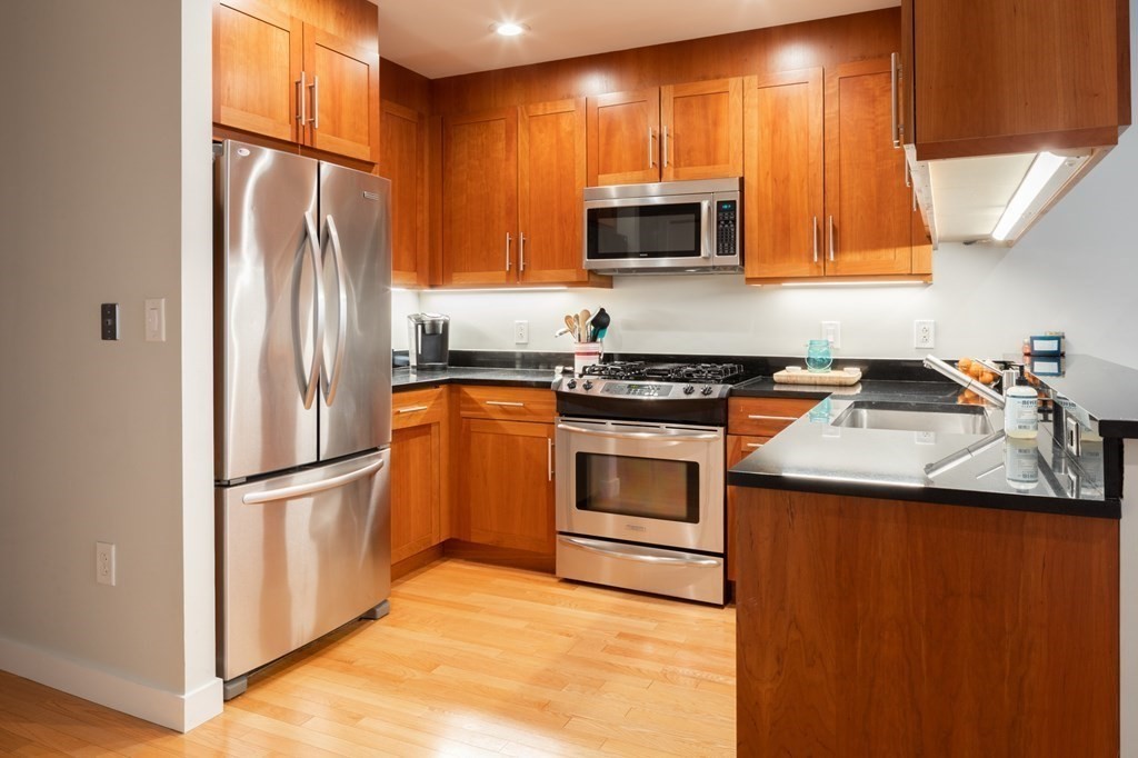 80 Broad Street, Unit 403 Boston, MA 02110 - Photo 9 of 16 a kitchen with a sink a stove and refrigerator