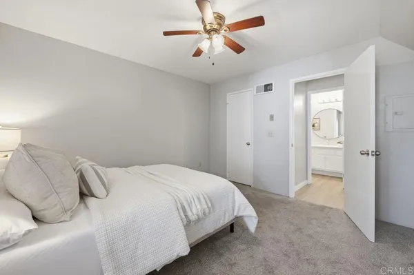 a bedroom with a bed and a ceiling fan