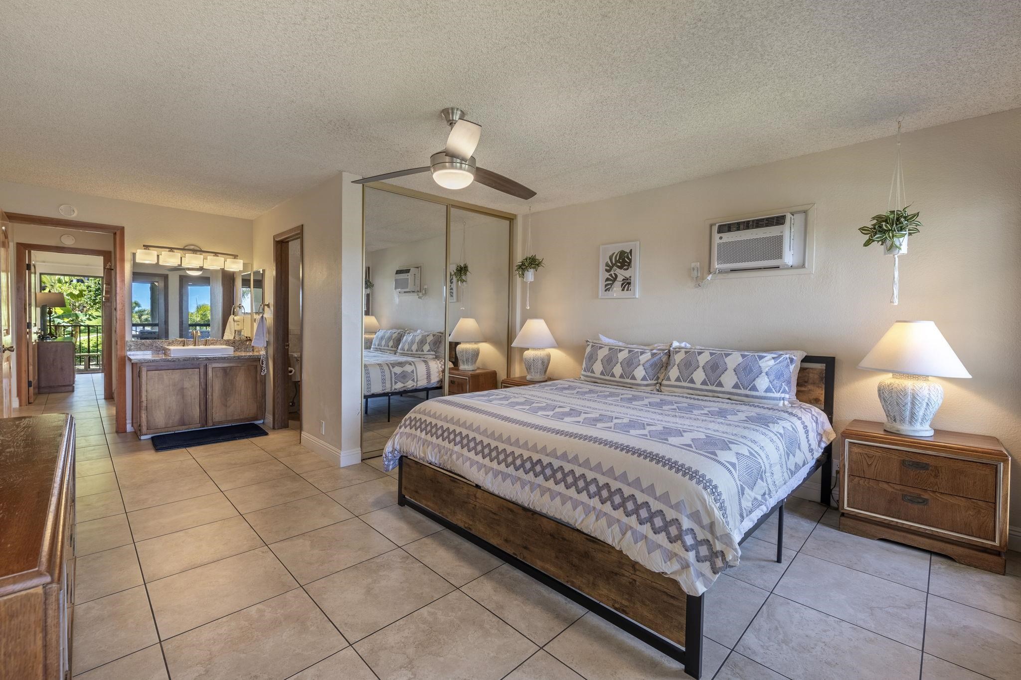 2881 South Kihei Road, Unit 59 Kihei, HI 96753 - Photo 24 of 37 a spacious bedroom with a bed and a chandelier