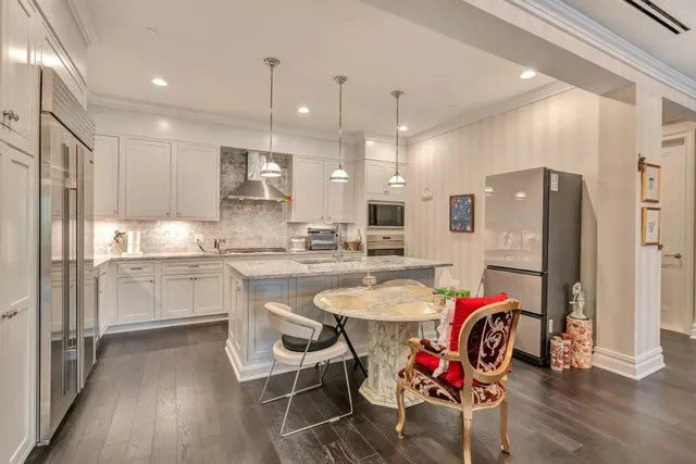 a kitchen with refrigerator cabinets dining table and chairs