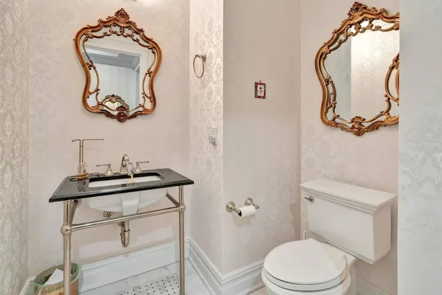 a bathroom with a toilet mirror and vanity