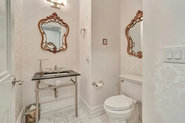 a bathroom with a toilet a sink and a mirror