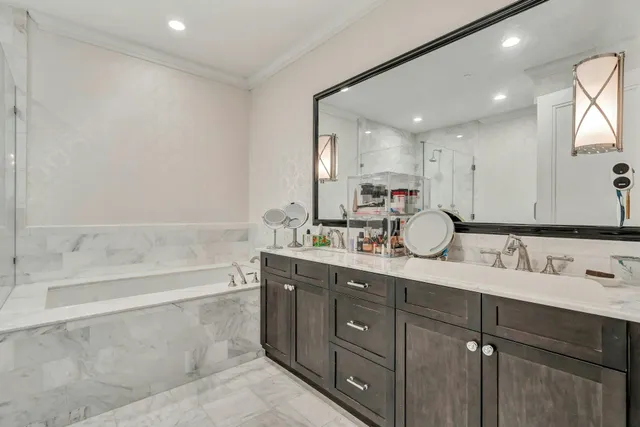 a bathroom with a tub sink double vanity granite and a mirror