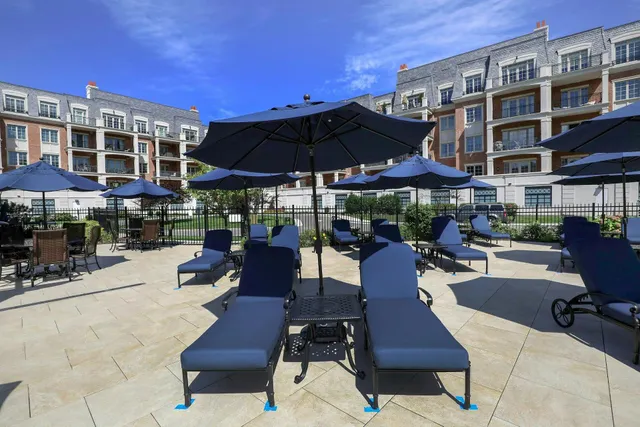 a view of a patio with a dining table and chairs under an umbrella